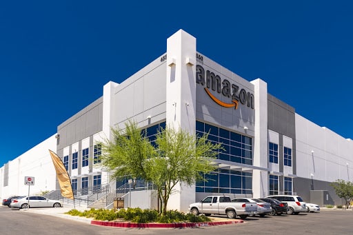 A perspective shot of an Amazon building showing the parking lot against the blue sky.